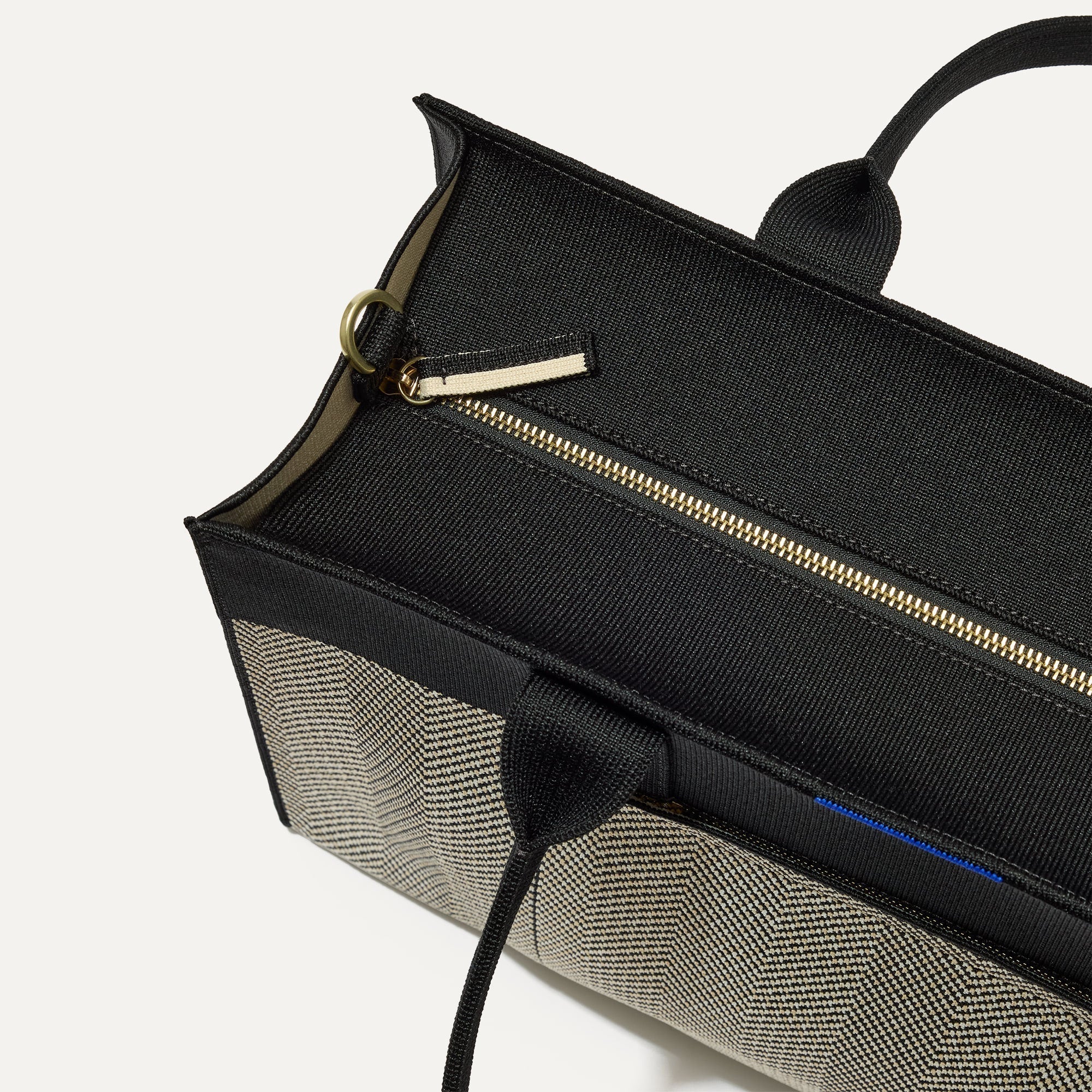 The Classic Tote in Black Herringbone, shown from above, with the top zipper closed. 