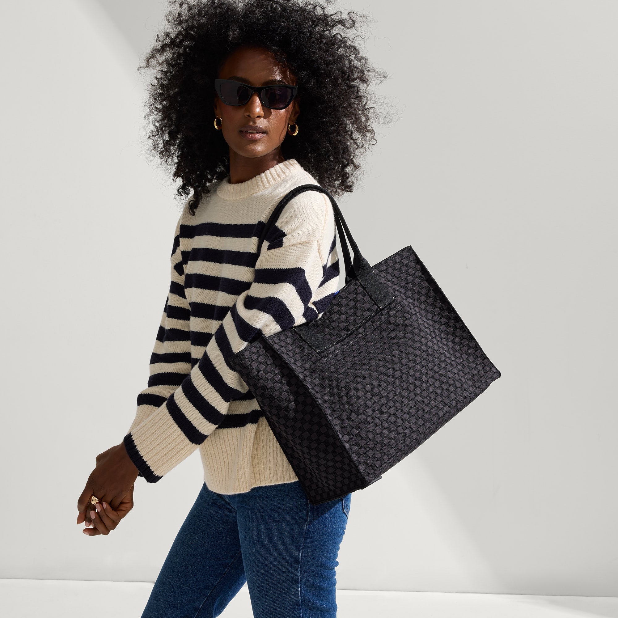 hover | The Classic Tote in Black Sand, worn over the shoulder by a model, shown from the side.