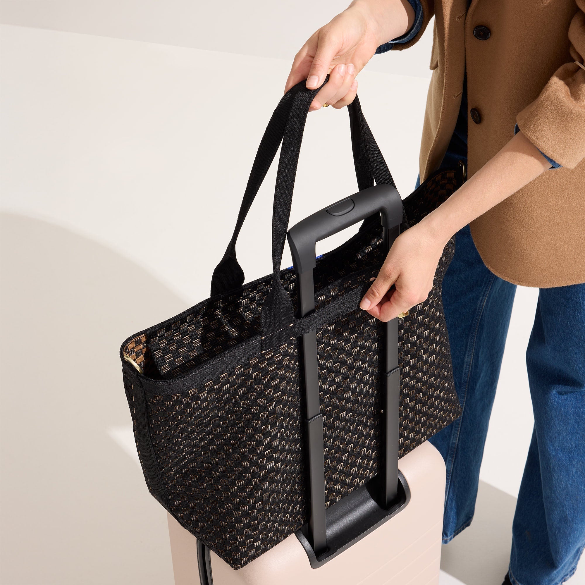 hover | Model holding The Zip Travel Tote in Night Song.