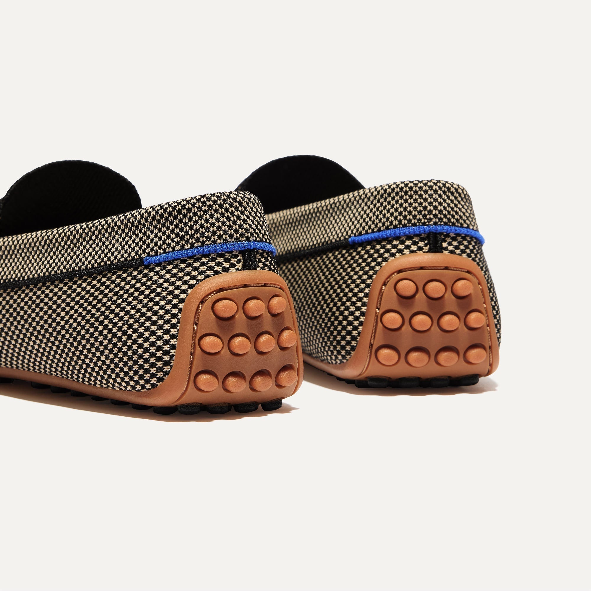 Close up of the heel of The Daily Driver in Classic Micro Check, with raised peg outsoles and Rothy's signature blue halo. 