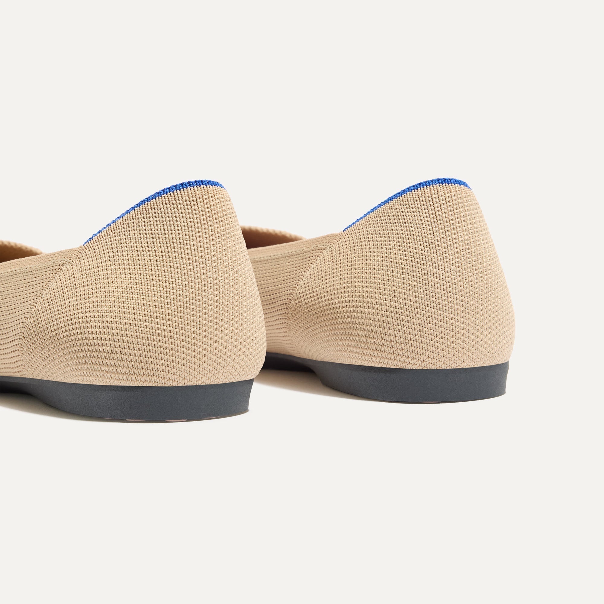 Close up of the heel of The Daily Flat in Ecru, with Rothy's signature blue halo. 