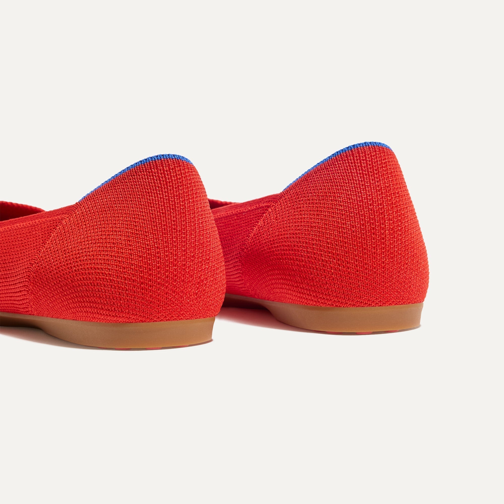Close up of the heel of The Daily Flat in Showstopper Red, with Rothy's signature blue halo. 