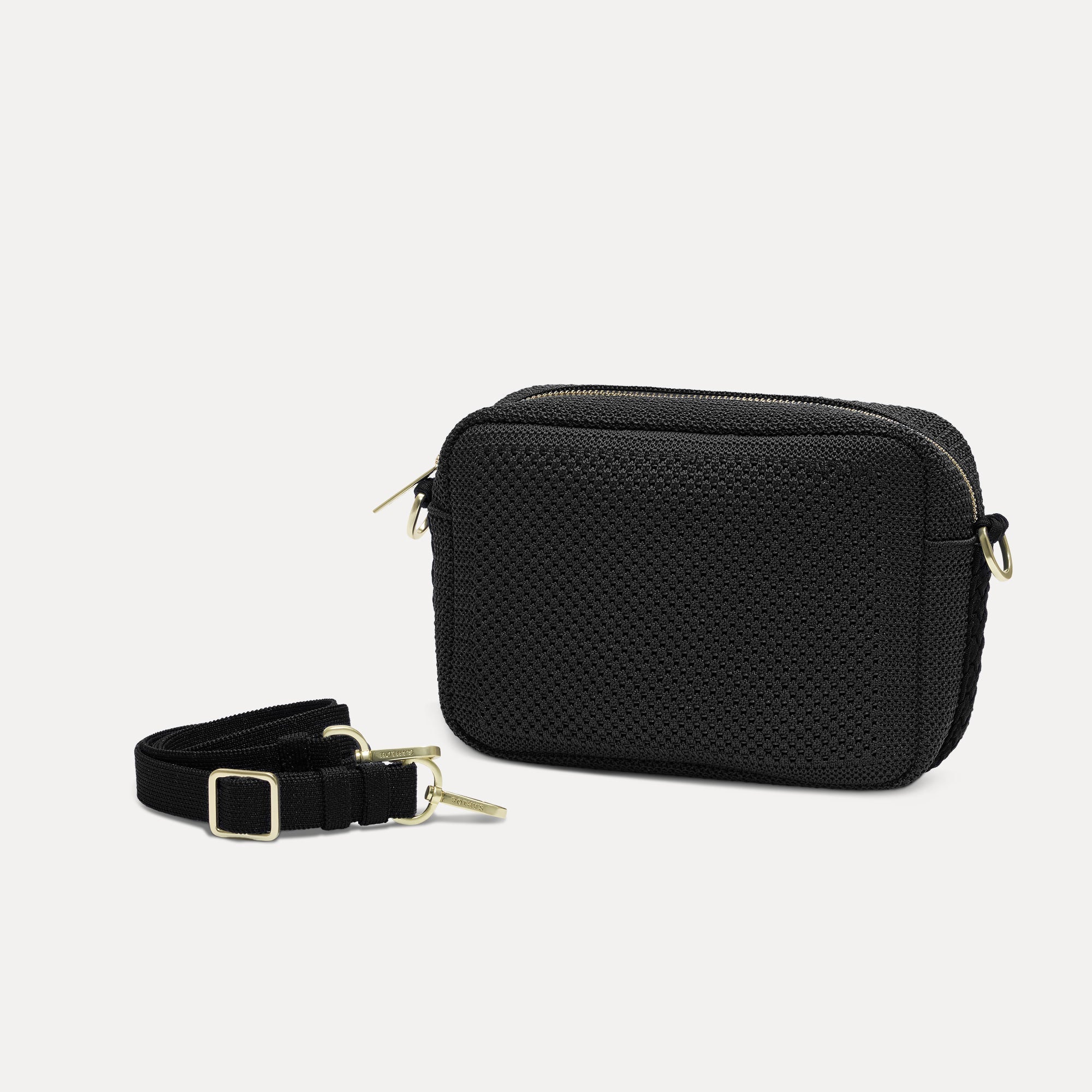 The Crossbody Camera Bag in Black Licorice Open-Knit shown by itself with removable strap. 